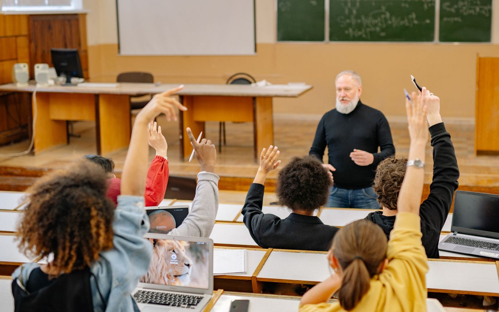 Older students raising their hands during a seminar